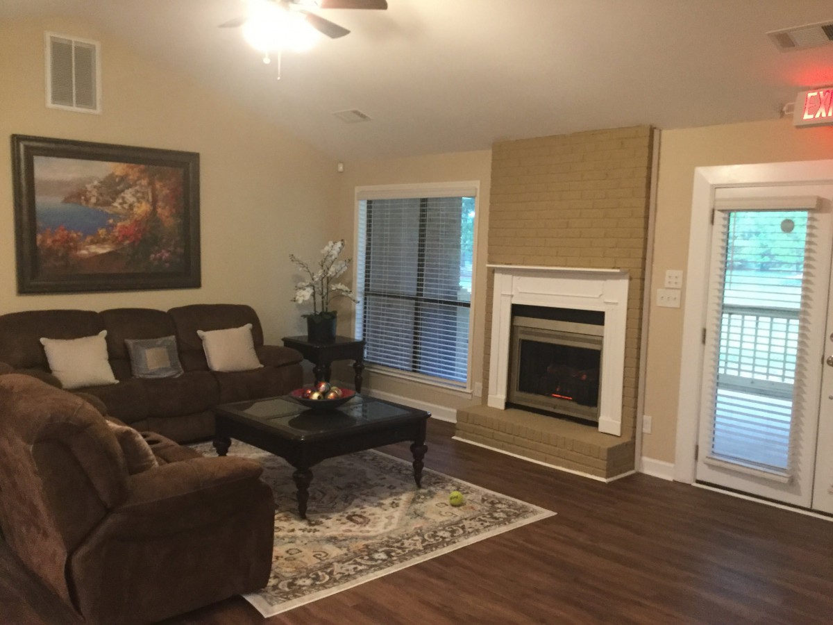 A cozy living room with a brown sofa, coffee table, and a fireplace.