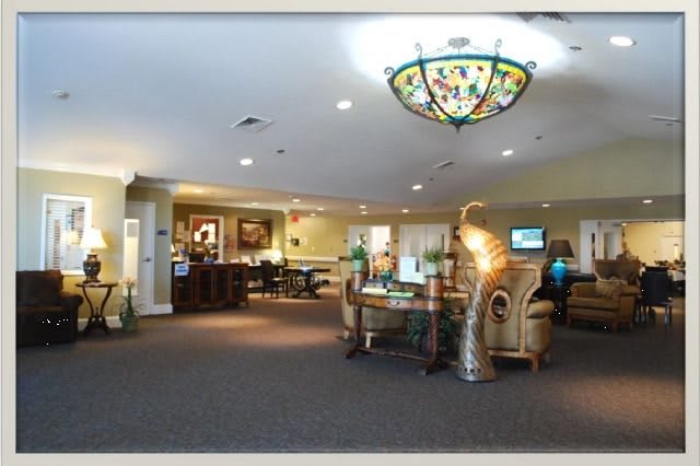 A spacious and elegantly decorated lobby area featuring a reception desk, seating areas, and a decorative chandelier.