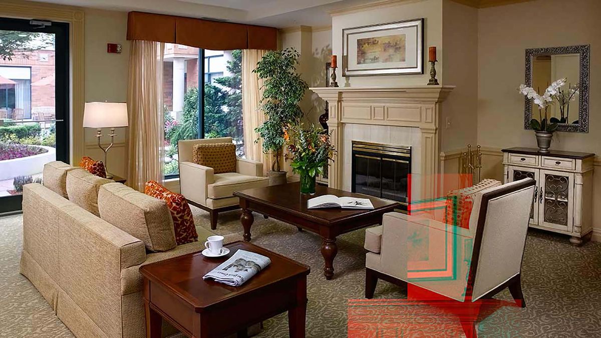 A cozy living room with elegant furniture, a fireplace, and greenery.