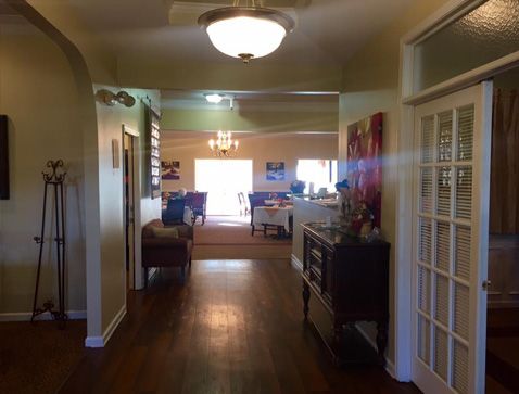 A cozy home interior featuring a well-lit hallway leading into a living room, with stylish furniture and wooden flooring.