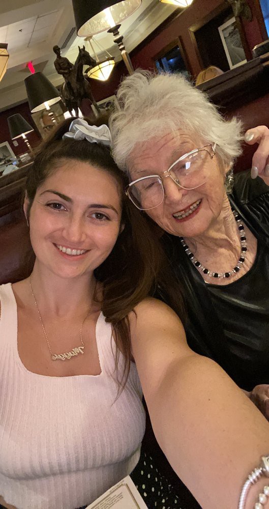 A young woman and an elderly woman smiling for a selfie.