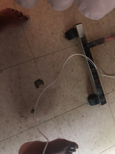 A household item with a cable lying on the floor.