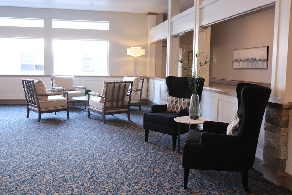 A cozy lobby seating area with comfortable chairs and a stylish lamp.
