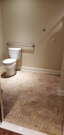 A simple and clean bathroom featuring a toilet against a neutral background.