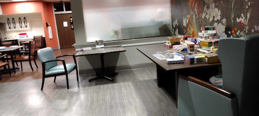An organized office space featuring two tables and a chair, with natural light streaming through the window.