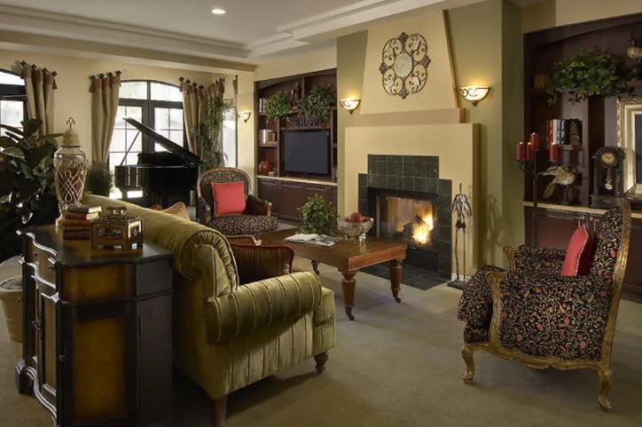 A cozy living room with traditional decor, featuring a fireplace and grand piano.