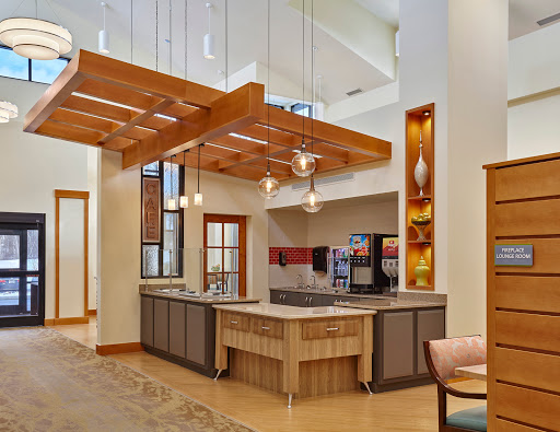 A stylish modern kitchen featuring wooden beams, contemporary lighting, and a spacious layout.