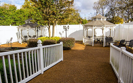 A peaceful outdoor garden featuring a charming gazebo and well-maintained landscaping.