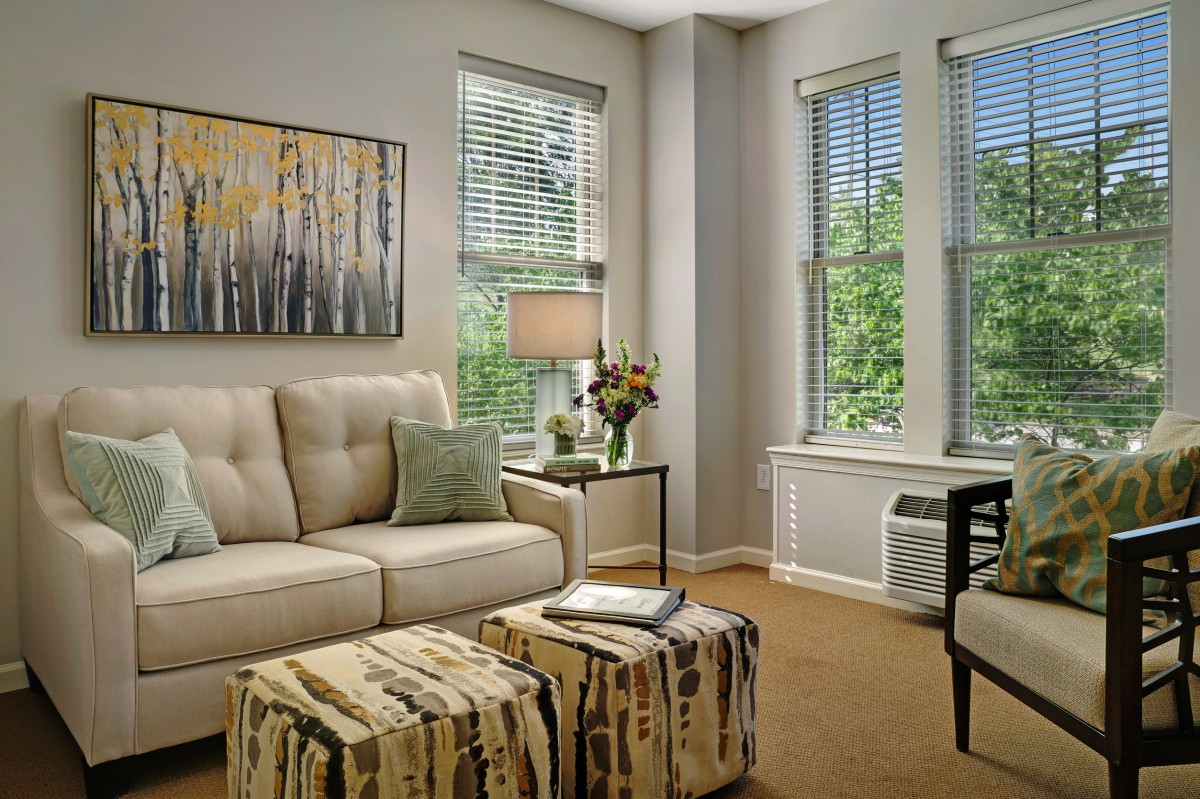 A modern living room with a comfortable sofa, large windows, and tasteful decor.