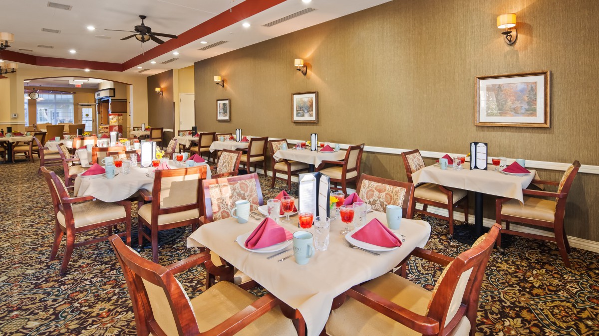 An elegantly set dining area in a restaurant with neatly arranged tables and chairs.