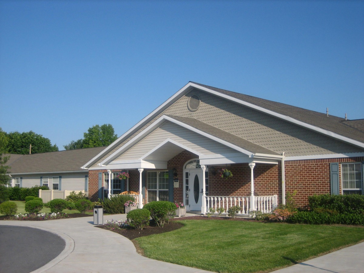 A residential building with a landscaped front yard and driveway.