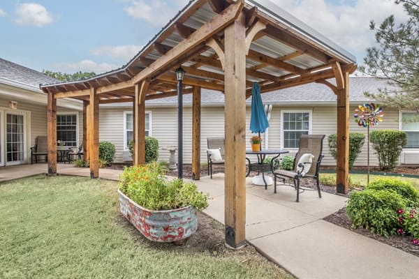 A cozy outdoor patio with a wooden pergola and seating area.