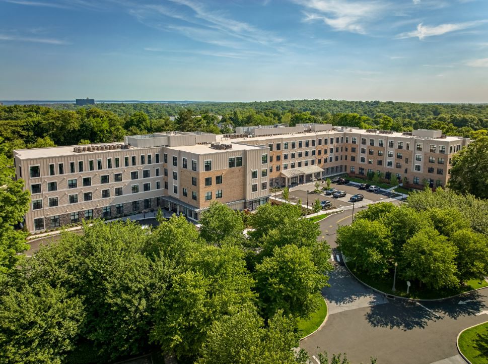 Aerial view of a large residential building surrounded by trees.