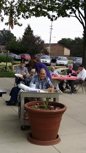 A cheerful gathering of seniors enjoying a meal outdoors.