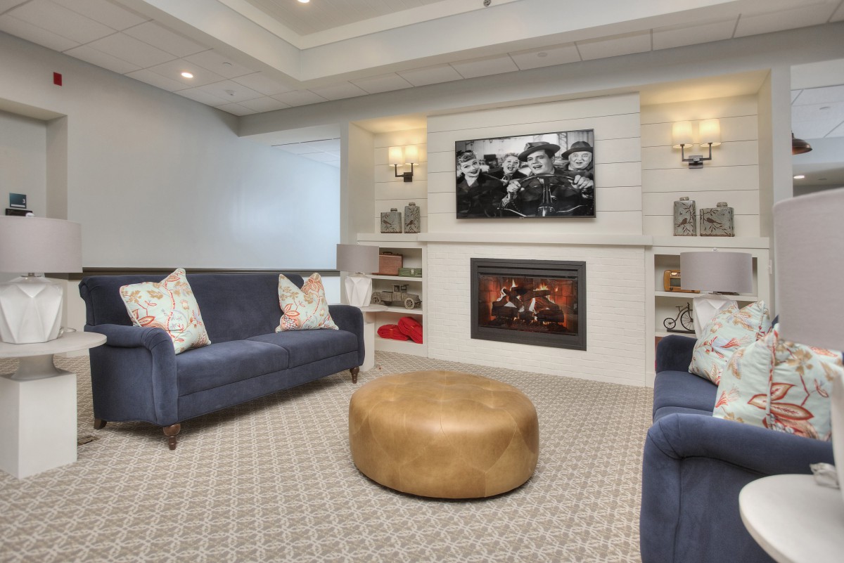 A modern living room featuring a fireplace, wall-mounted television, and comfortable sofas.