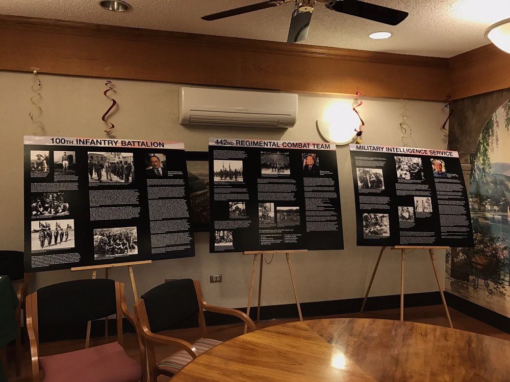 An indoor exhibition showcasing informational posters in a meeting room setting.