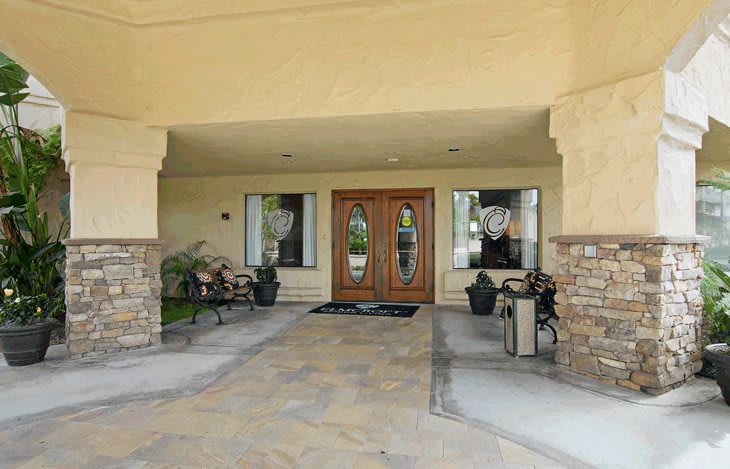 A welcoming building entrance with double wooden doors and decorative stone accents.