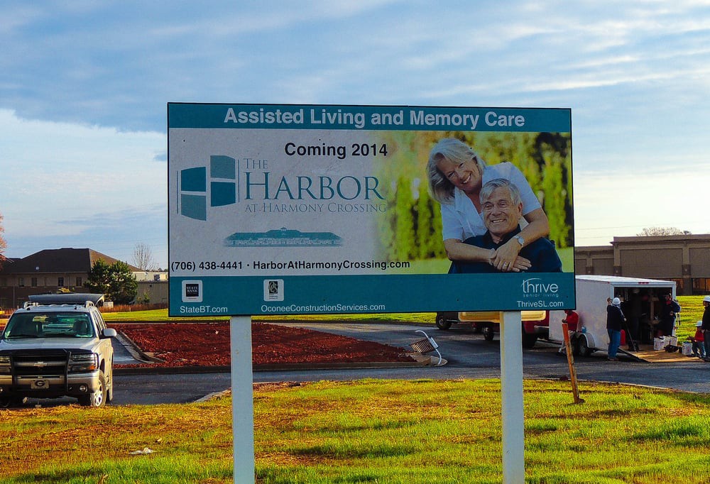 A sign advertising a new assisted living and memory care facility, set to open in 2014.