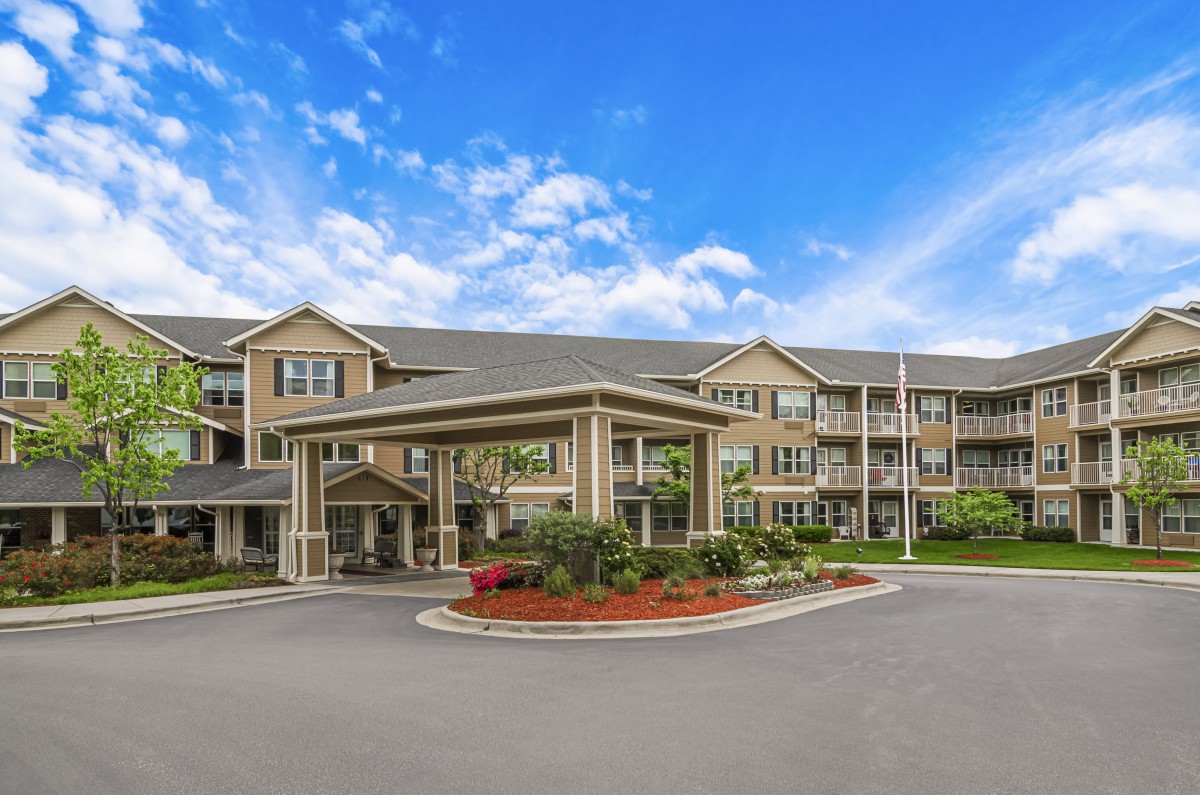 Exterior view of a residential assisted living facility with landscaped entrance.