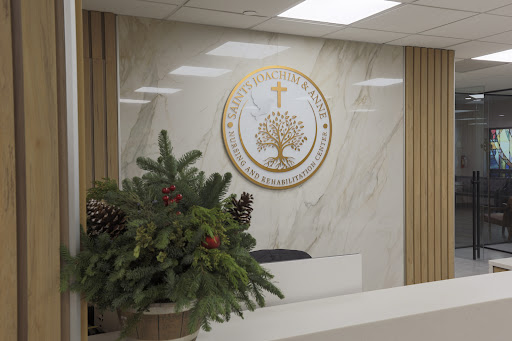 A serene office reception area featuring a decorative logo and potted plants.