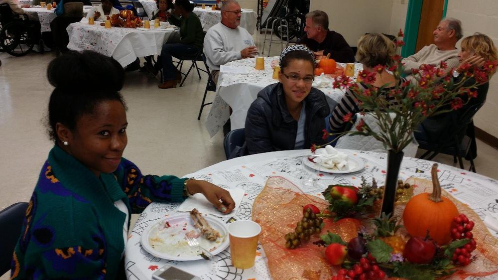 A group of people enjoying a meal together at an indoor event.