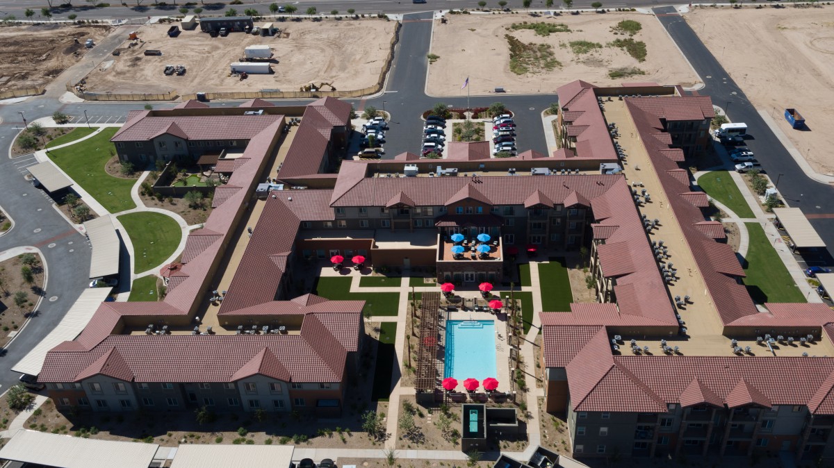 Aerial view of a residential complex with swimming pools and landscaped courtyards.