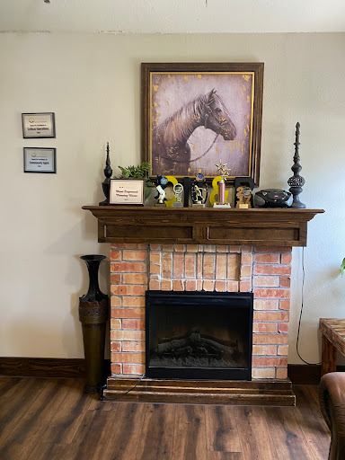 A charming fireplace mantel adorned with a horse portrait and decorative items.