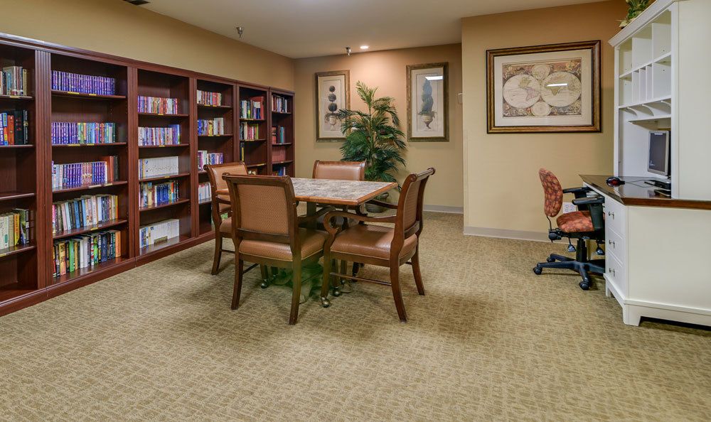 A cozy library corner with bookshelves, a table, and chairs.
