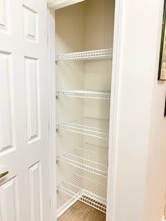 An empty closet with wire shelves and a white door.