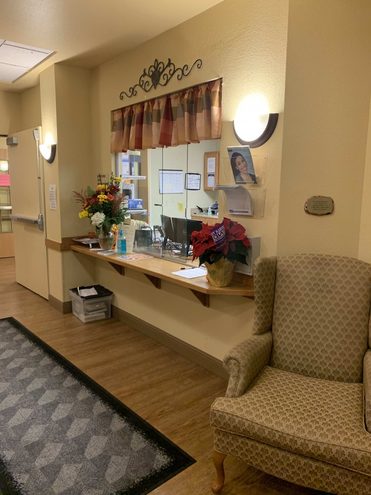 A warm and welcoming reception area with a comfortable chair and floral decorations.