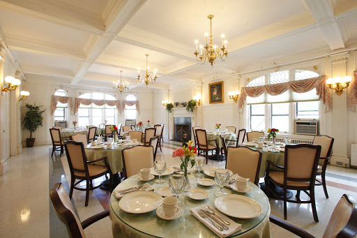 An elegant dining room set for a meal, featuring beautifully arranged tables and chandeliers.