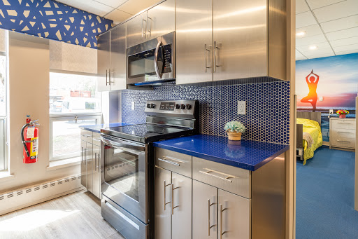 A sleek and modern kitchen featuring stainless steel appliances, a vibrant blue countertop, and an eye-catching decorative backsplash.