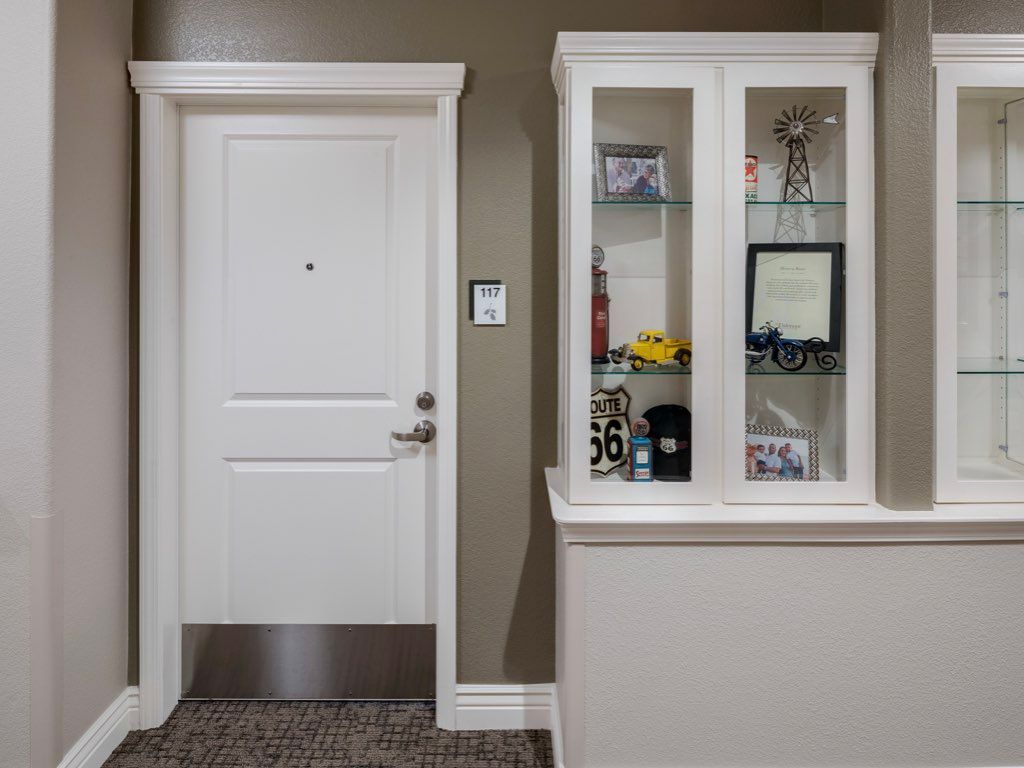 A cozy interior space with a white door and a display cabinet filled with decor items.