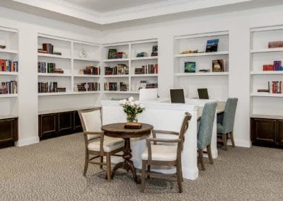 A cozy library corner with bookshelves, a reading table, and comfortable seating.