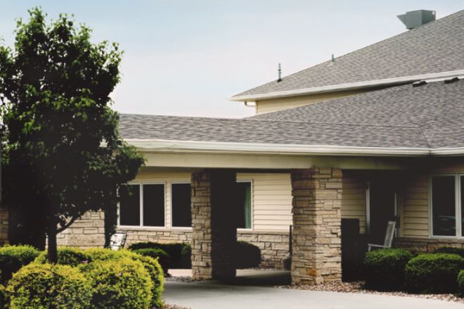A suburban home with stone pillars and a neatly maintained exterior.