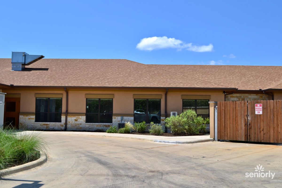 A single-story office building with a parking lot on a sunny day.