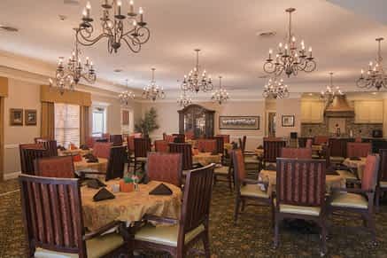 An elegant dining room featuring chandeliers and classic furniture.