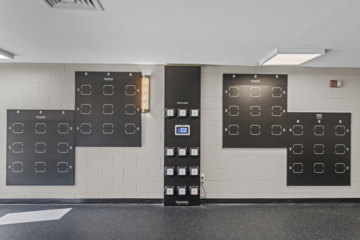A modern gym with a rock climbing training wall featuring various holds.