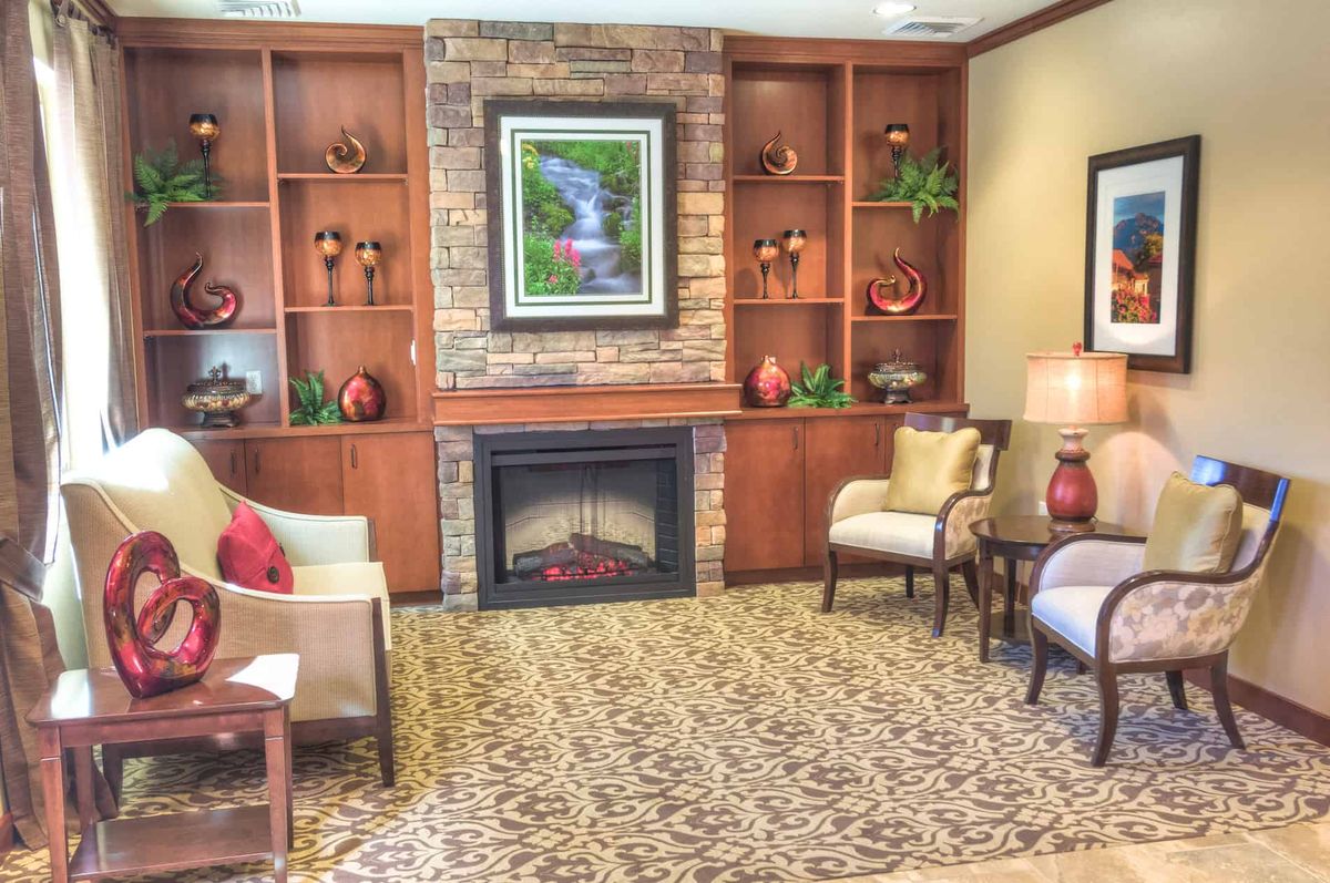 A cozy living room with a fireplace and decorative shelves.