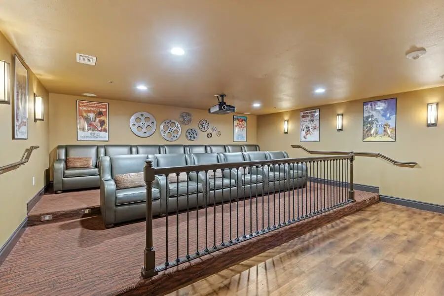 A cozy home theater room with tiered seating and movie-themed decor.