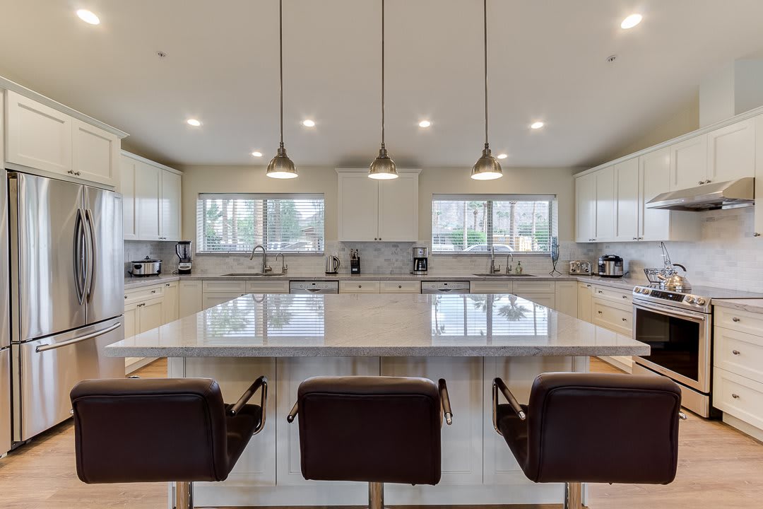 A spacious, modern kitchen with a large island and pendant lighting.