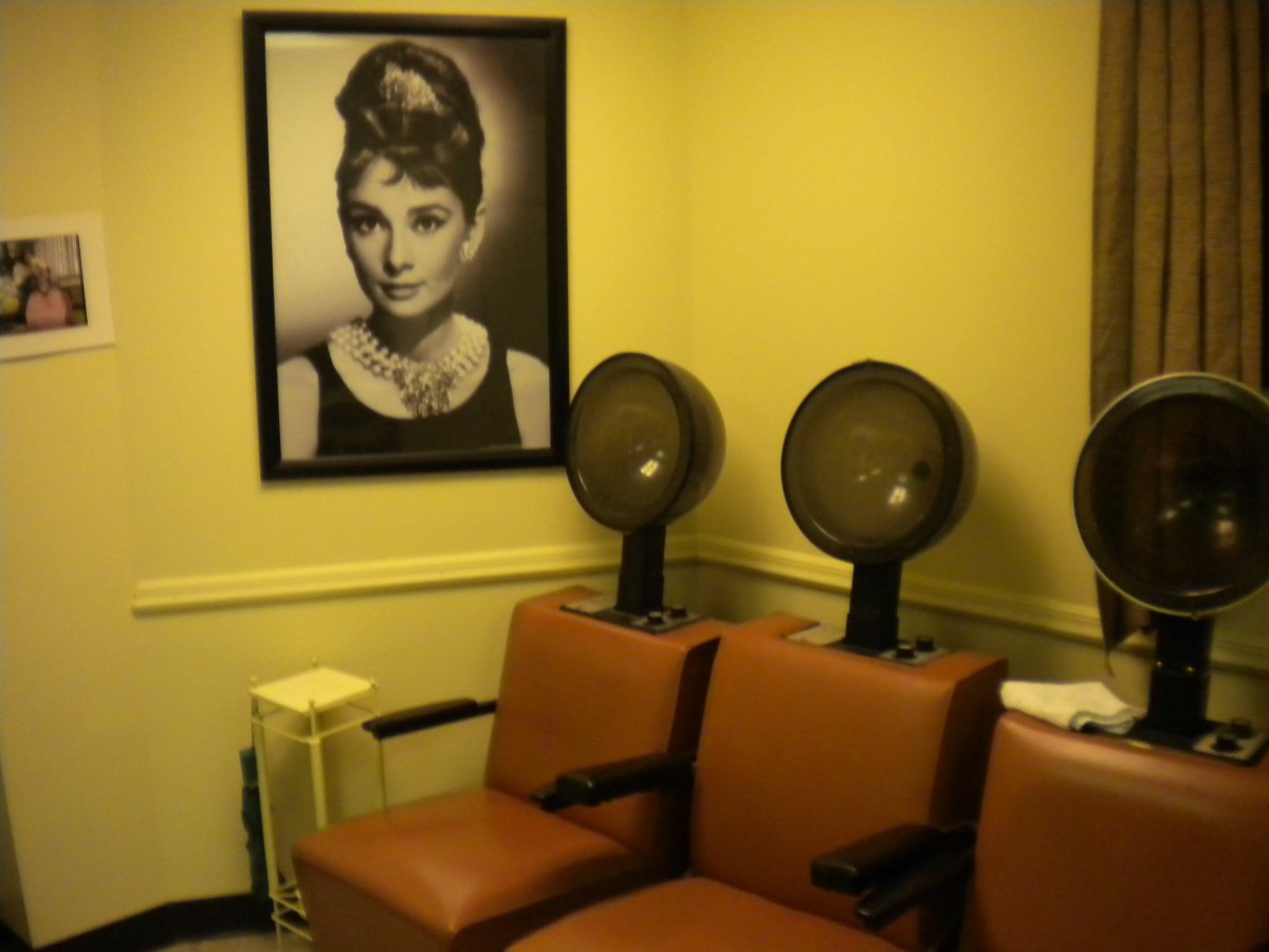 A vintage-style salon interior with hairdryers and a classic poster on the wall.