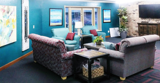 A cozy living room setup featuring comfortable sofas, decorative art, and a touch of greenery.