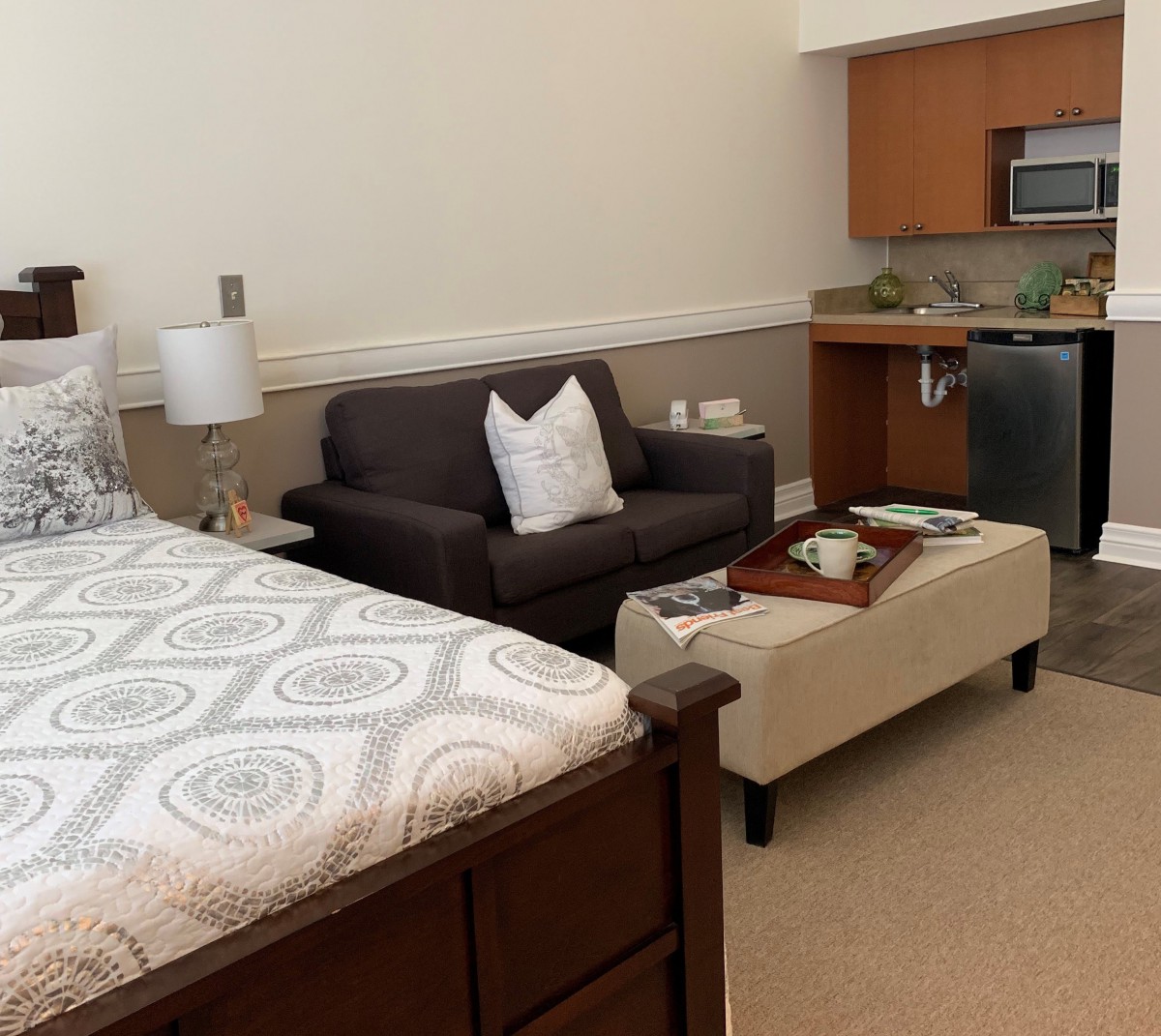 A cozy studio apartment with a bed, sofa, and kitchenette.