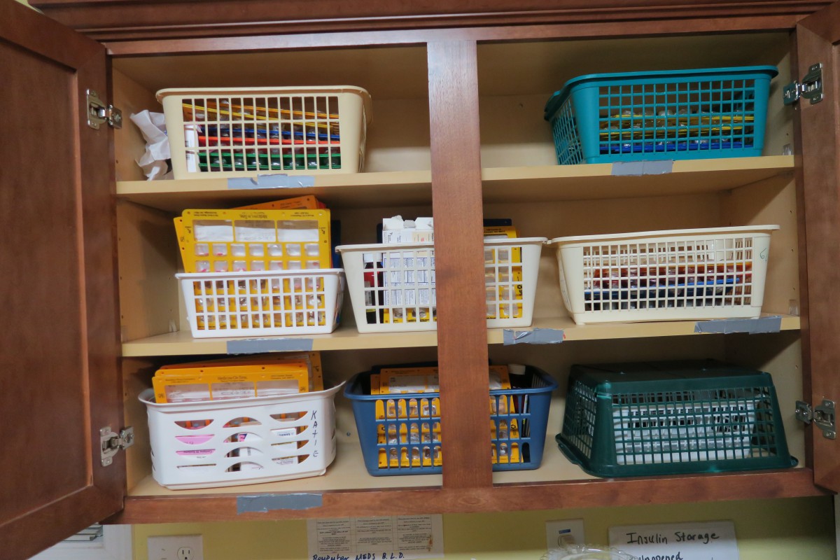 An organized shelving unit with baskets containing office supplies.