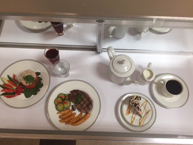 A display of plated dishes accompanied by a tea set, showcasing a variety of meal options.