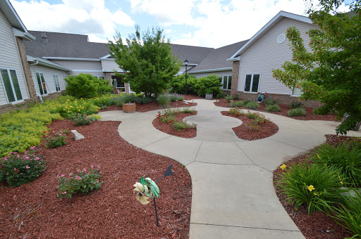 A beautifully landscaped garden with a winding pathway surrounded by lush plants and flowers.