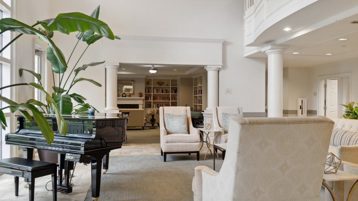 A spacious and modern living room featuring elegant furniture and a grand piano.