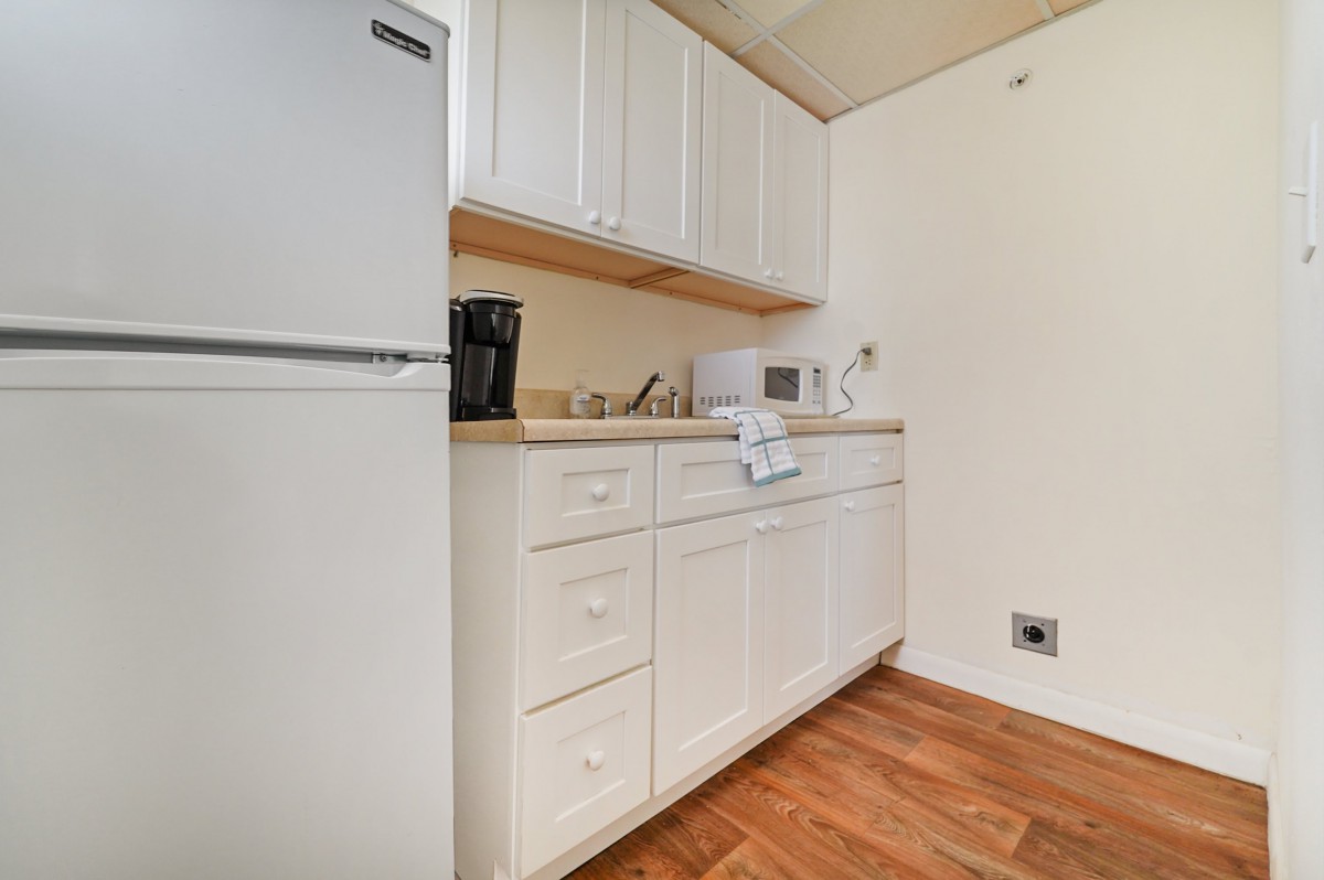 A compact kitchen with white cabinets and appliances.