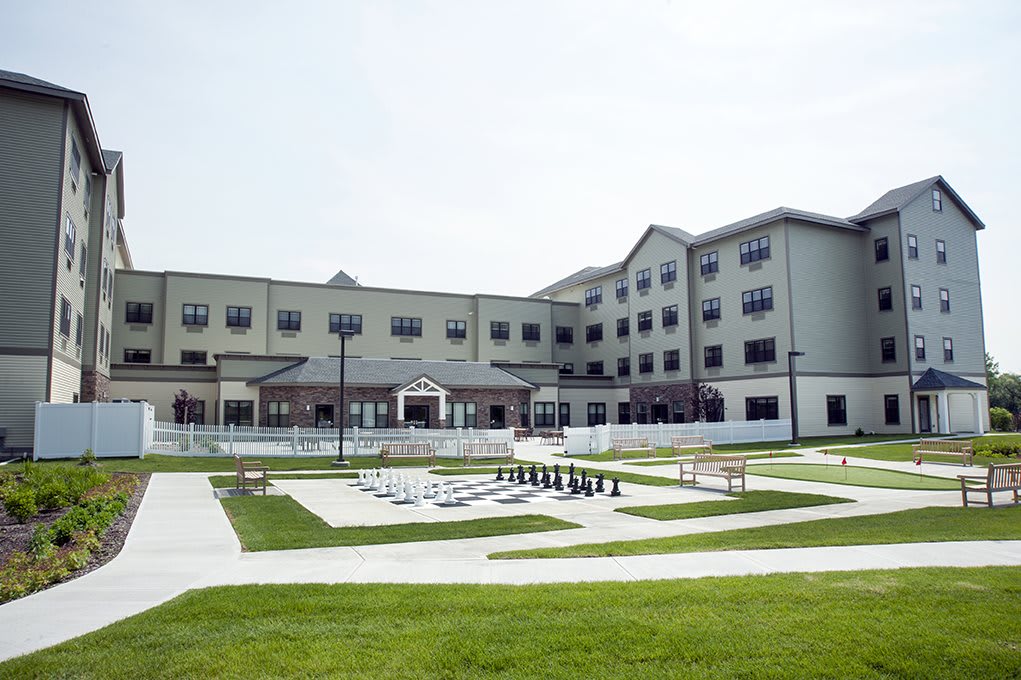 A modern building with a well-maintained green lawn and paved pathways.
